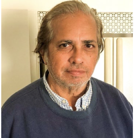 An older man with gray hair and a thoughtful expression, reflecting on his journey towards stable housing and support.