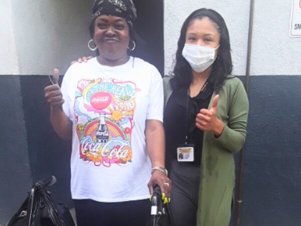 Yvette gives a thumbs up with her case worker.