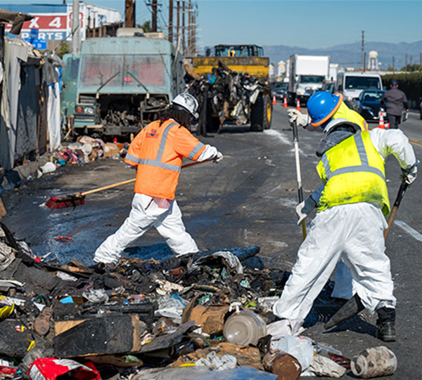 Crews clean up trash and refuse at a Pathway Home cleanup.