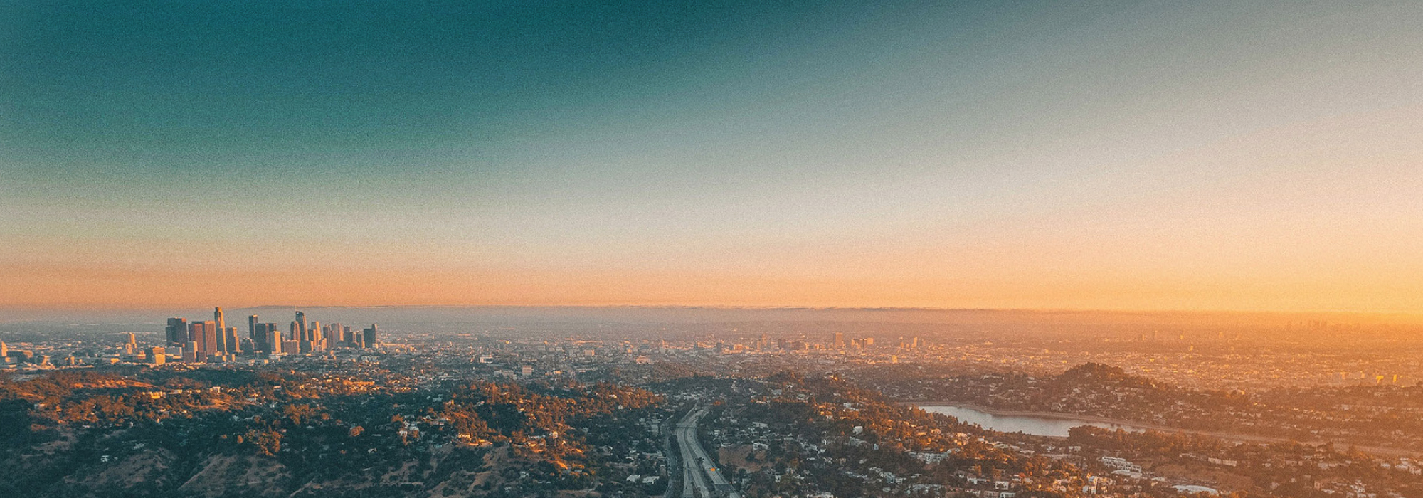 A panoramic view of Los Angeles at sunset, symbolizing hope and community resilience in addressing homelessness.