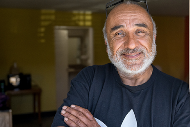 A smiling man in a welcoming space, embodying hope and resilience as he transitions to stable housing.