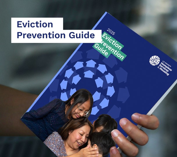 A hand holding the 2025 Eviction Prevention Guide, featuring diverse individuals engaged in supportive conversation.
