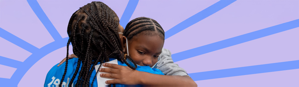 A mother embraces her child, both finding comfort and hope in their journey towards stability and support.