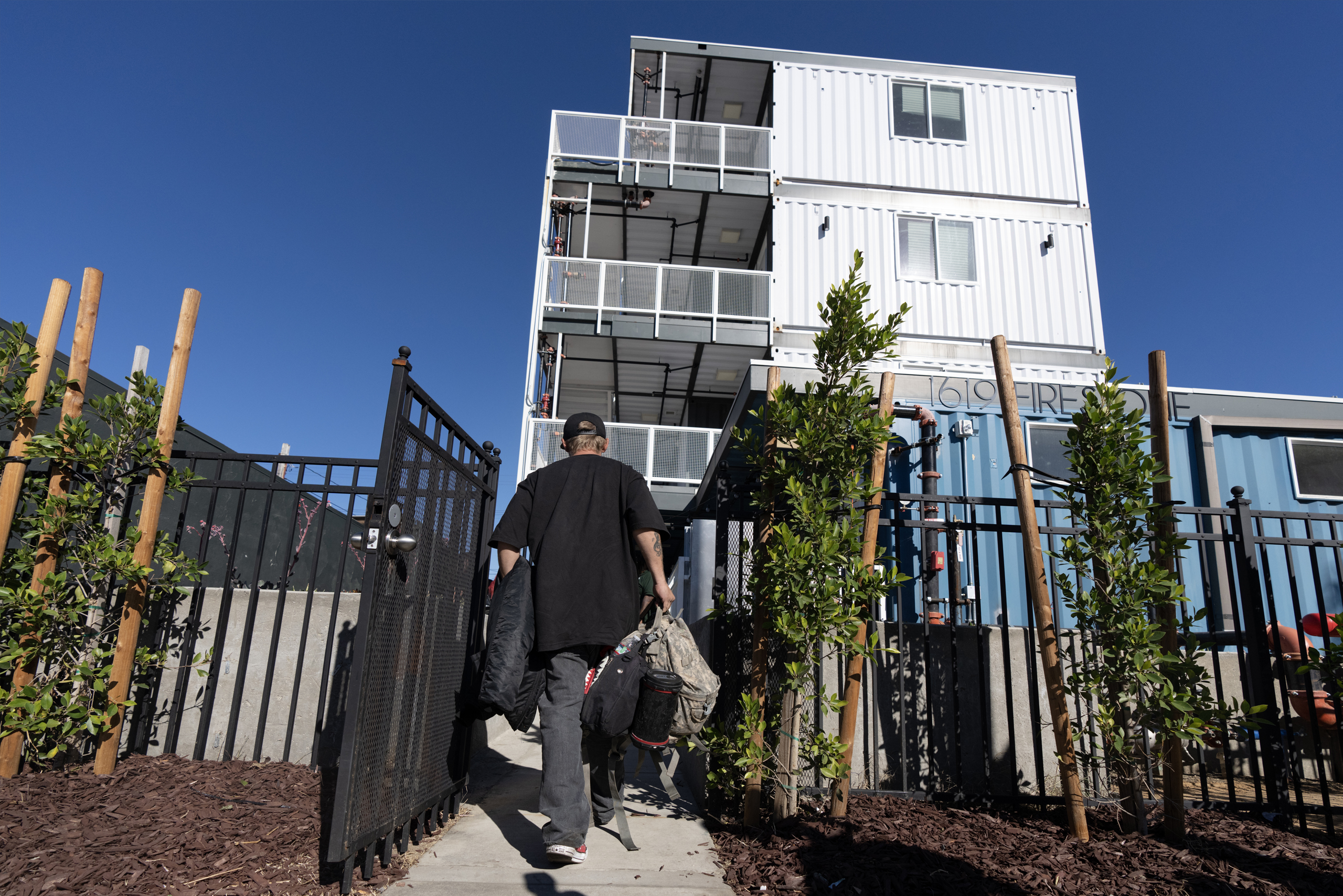 Man walking into an apartment building.