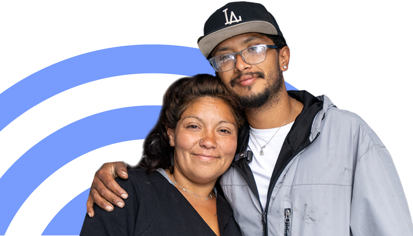 A couple embracing, smiling with hope, symbolizing support and progress in their journey toward stable housing.