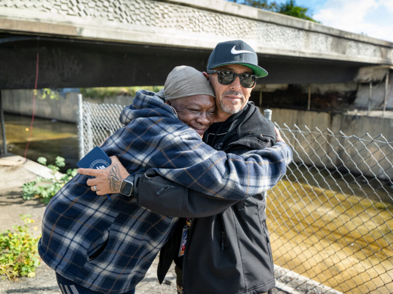 Tashawn hugs HOPICS outreach worker Hector Carranza before moving to interim housing during a Pathway Home operation in Willowbrook, Wednesday, April 1, 2026. (Photo by Michael Owen Baker)